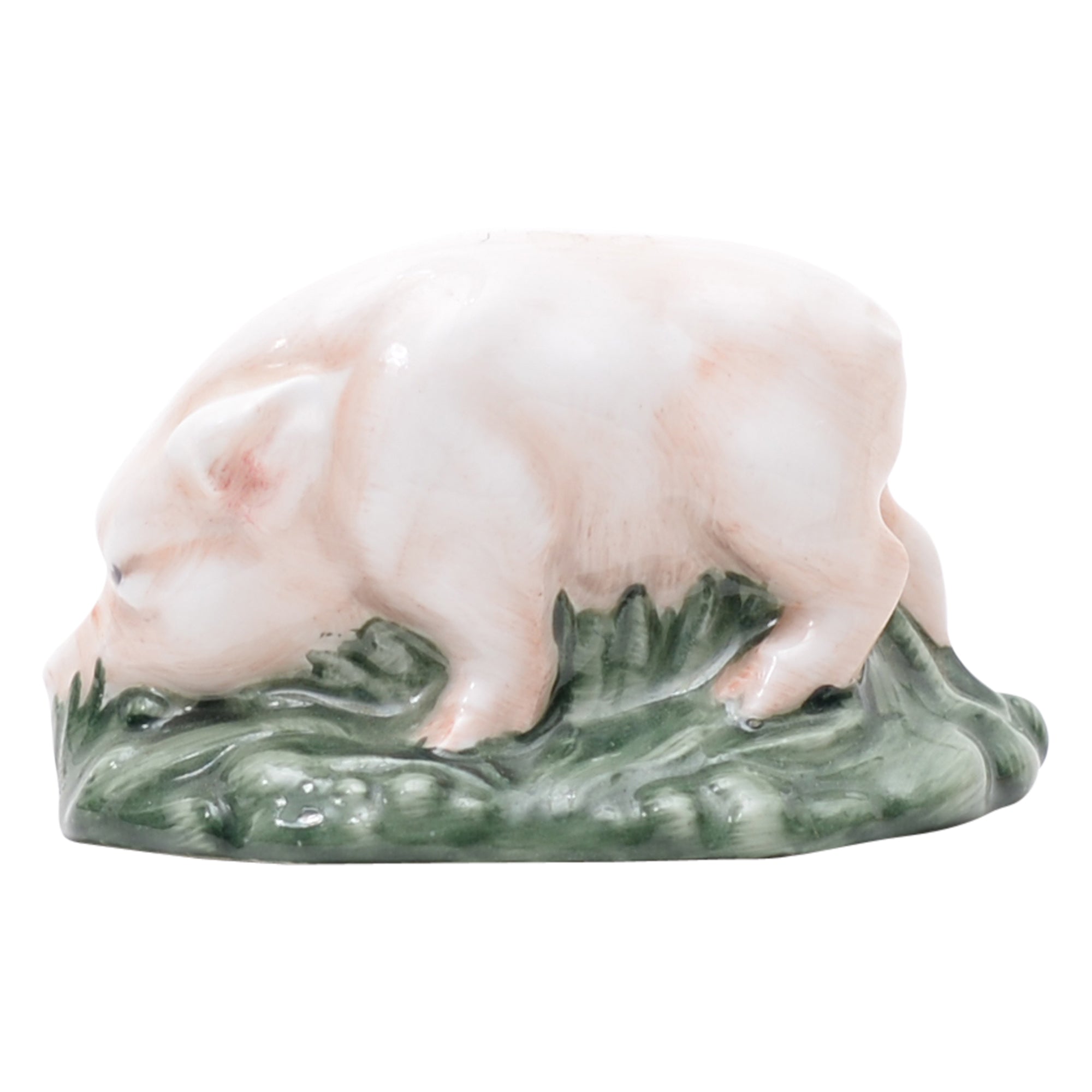 Pink piglet on green grassy mound