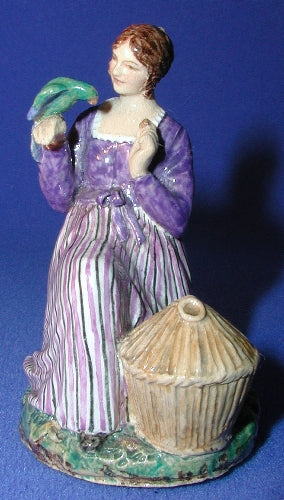 Dulwich,mini,lady seated,parrot on hand,cage at feet,